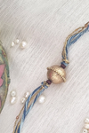 Gold Plated Rakhi With Blue Threads With Chandan Beads