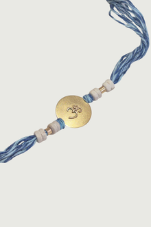  Gold Plated Om Rakhi With Blue Thread And Tulsi Beads
